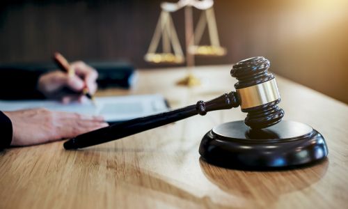 Richterhammer, Waage der Gerechtigkeit und Dokumente auf einem Tisch. Gerichtsszene.