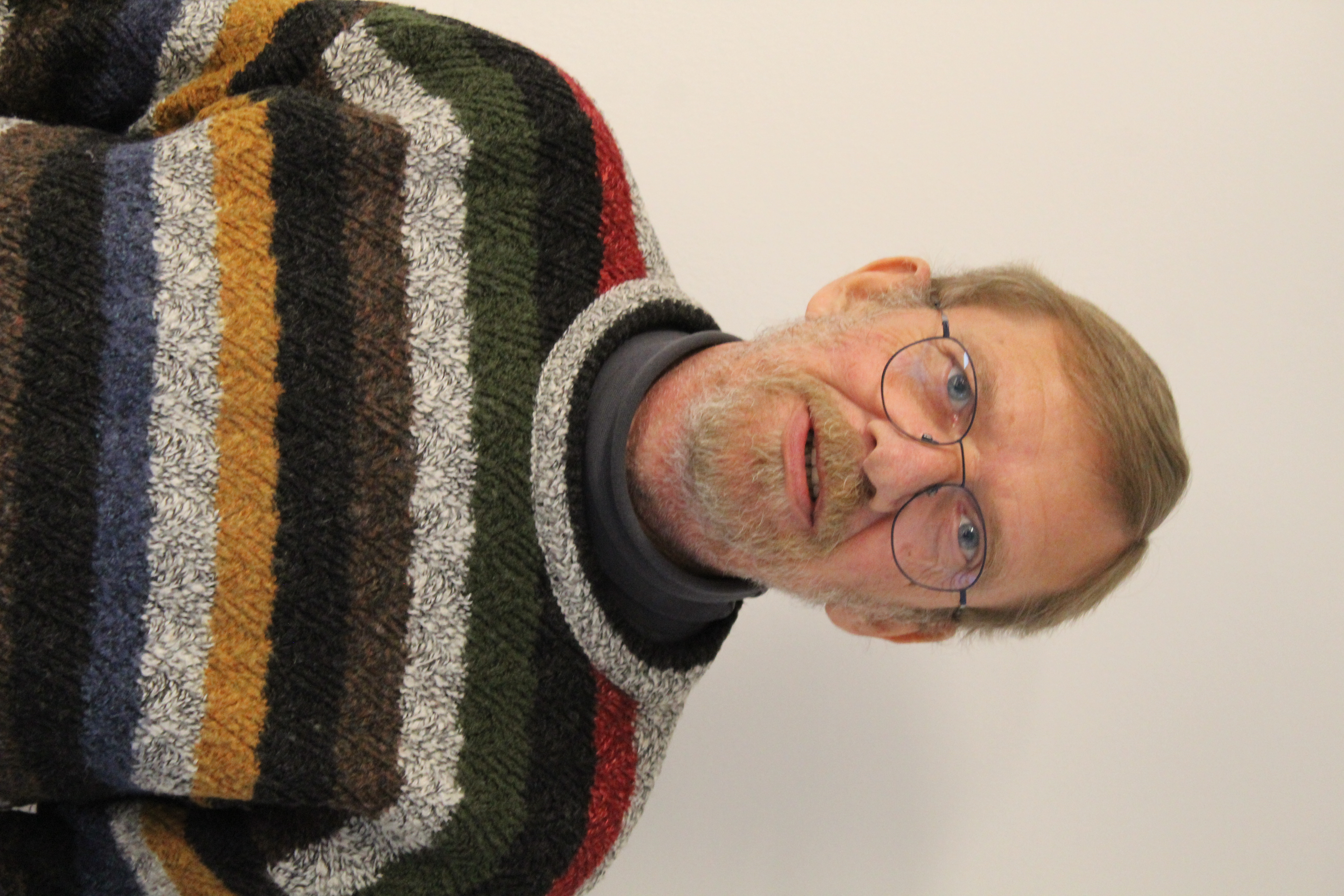 Mann mit Brille und gestreiftem Pullover. Kirchengewerkschaft Hessen.