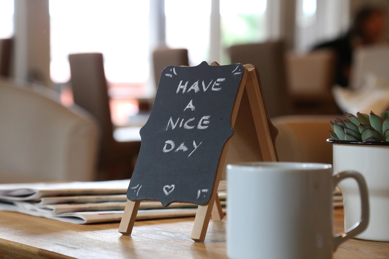 Tafel mit "Have a nice day" in Café-Szene. Freundliche Botschaft.