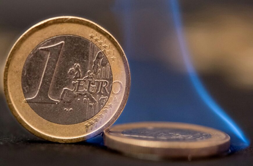 Burning euro coins with blue flames representing financial risk or crisis.