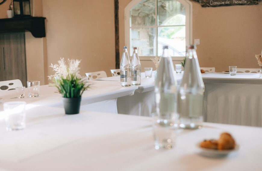 Modern conference room setup with bottled water and croissants, ideal for meetings.