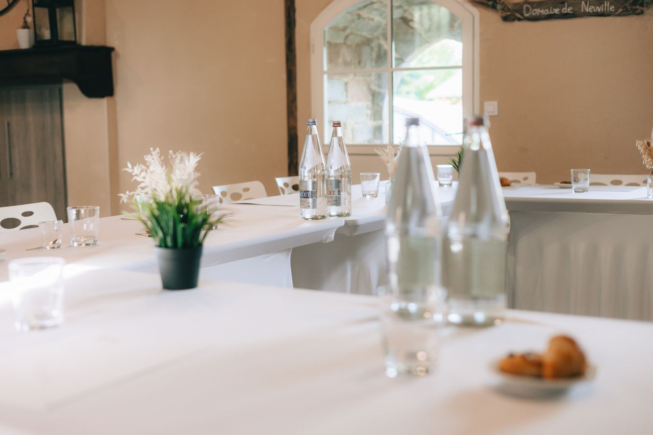 Modern conference room setup with bottled water and croissants, ideal for meetings.